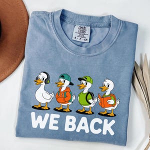 Camiseta Comfort Colors® We Back, Volta às Aulas Silly Goose, Camiseta Humorística Retro Goose para o Primeiro Dia, Presente para Professor, Tendência, Fofa, Engraçada e com Clima Escolar