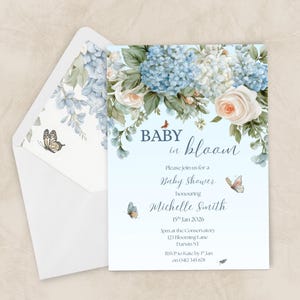 Könnte beinhalten: Babyparty-Einladung mit floralem Design. Die Einladung zeigt blaue Hortensien, weiße Rosen und Schmetterlinge. Der Text lautet "Baby in bloom" und enthält Details zur Babyparty von Michelle Smith.
