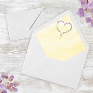 May include: A white envelope with a yellow envelope inside. The yellow envelope has a watercolor design of a heart made of purple flowers.