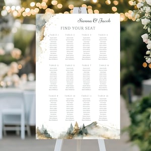 Könnte beinhalten: Ein Hochzeits-Sitzplan mit den Namen "Sienna & Jacob" oben. Die Tabelle ist in Tische mit den Namen der Gäste unterteilt. Das Design umfasst Aquarellbilder von Bergen und Wäldern mit goldenen Akzenten.