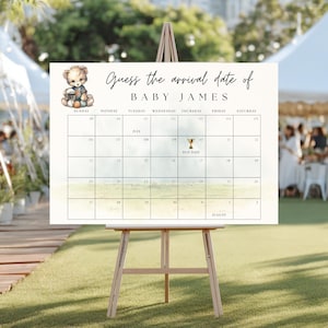 Könnte beinhalten: Ein weißer Babyparty-Kalender auf einer Staffelei mit dem Text "Erraten Sie das Ankunftsdatum von BABY JAMES". Der Kalender zeigt eine Teddybär-Grafik und ein Raster, in dem die Gäste das voraussichtliche Geburtsdatum erraten können. Der Kalender wird im Freien angezeigt.