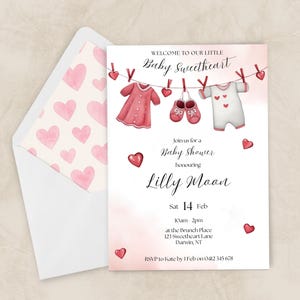 May include: A baby shower invitation with a pink and white design. The invitation features illustrations of baby clothes, hearts, and the text "Baby Sweetheart" and "Lilly Moon". The envelope has a pink heart pattern. The event is on Sat 14 Feb.