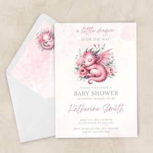 May include: A baby shower invitation with a pink watercolour dragon illustration. The text reads "a little dragon is on the way" and includes event details, such as the date, time, and location. The invitation is accompanied by a matching envelope.