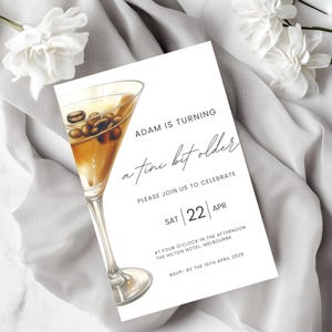 May include: A white invitation card with the text "ADAM IS TURNING a tini bit older" and a watercolour illustration of a martini glass filled with coffee beans. The invitation is for a celebration on April 22nd.