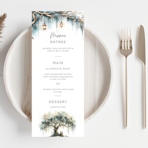 May include: A wedding menu card with a watercolor illustration of a tree and a couple. The menu includes entree, main, and dessert options. The card is placed on a wooden plate with a fork and knife.