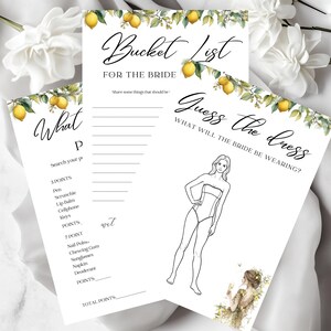 May include: Three white paper sheets with black text and lemon illustrations. The top sheet reads "Bucket List for the Bride." The middle sheet says "What P" with a list of items. The bottom sheet says "Guess the dress."