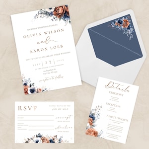 Peut inclure: Ensemble de papeterie de mariage avec des motifs floraux bleu marine, rouille et blush. L'invitation comprend les noms d'Olivia Wilson et d'Aaron Loeb, avec les détails de la cérémonie et de la réception. Une carte RSVP et une enveloppe sont également incluses.