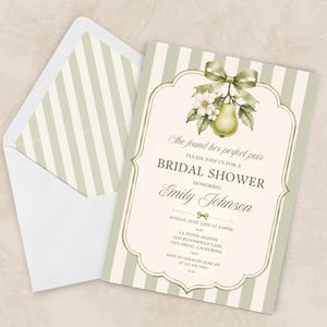 May include: A bridal shower invitation with a pear and floral design. The invitation has a green and white striped background, with text that reads "She found her perfect pair" and event details. An envelope with a matching striped pattern is also visible.
