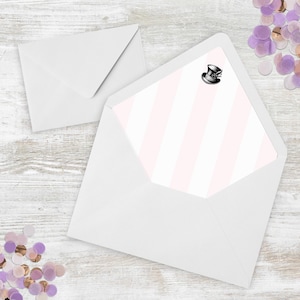 Puede incluir: Dos sobres blancos, uno abierto para revelar un interior a rayas rosas y blancas. Una pequeña ilustración de un sombrero de copa negro está en la esquina superior derecha. Confeti disperso en tonos morados y dorados.