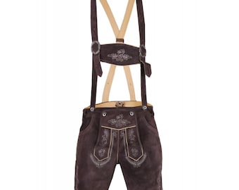 May include: Brown leather lederhosen with suspenders. The shorts feature decorative embroidery and silver-colored metal buckles. The suspenders are made of light-colored wood and brown leather.