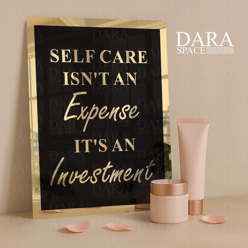 May include: A black and gold framed sign with the text "SELF CARE ISN'T AN EXPENSE IT'S AN INVESTMENT". Beside the sign are two pink cosmetic containers and a tube. The brand name "DARA SPACE" is in the upper right.