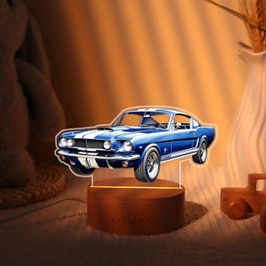May include: A blue and white classic car night light. The car is a detailed illustration with white racing stripes. The light sits on a wooden base with the name "Mike" engraved. The light is powered by a cord.