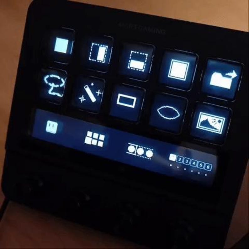 May include: A black MARS GAMING control panel with multiple illuminated square buttons displaying various white icons. The panel has a lower section with a series of white icons and numbers. The buttons and icons glow with a blue light.