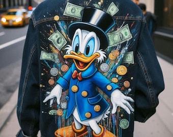 May include: Dark blue denim jacket featuring a colorful illustration of Scrooge McDuck surrounded by money. The artwork includes dollar bills and coins, with Scrooge wearing a blue coat and top hat. The jacket is a classic style with a button-up front.