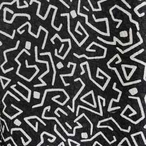 Puede incluir: Tela negra con un patr&oacute;n geom&eacute;trico blanco. El patr&oacute;n est&aacute; formado por l&iacute;neas y formas que crean un dise&ntilde;o complejo.
