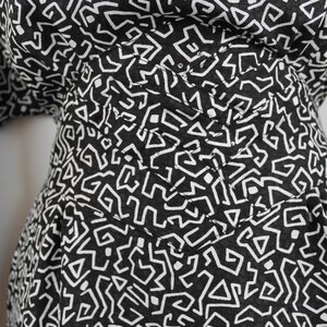 Puede incluir: Tela con estampado geom&eacute;trico en blanco y negro. La tela tiene una superficie texturizada y est&aacute; hecha de un material suave y ligero.