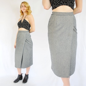 May include: A gray and white houndstooth wrap skirt with a high waist and a midi length.