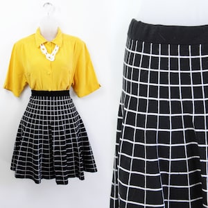 May include: A black and white grid pattern skater skirt. The skirt is made of a knit fabric and has a flared silhouette.