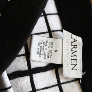 May include: A white tag with black text attached to a black and white checkered fabric. The tag reads "CARMEN", "S", "80% RAYON 20% NYLON", "MADE IN CHINA", "RN# 93178", "SEE REVERSE FOR CARE".