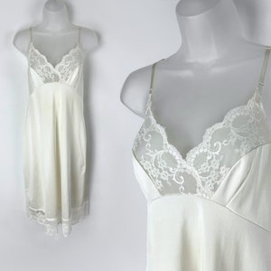 May include: A white slip dress with a lace bodice and a scalloped hem.