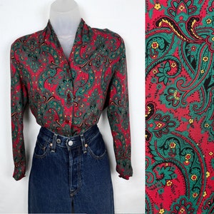 May include: A red, green, and yellow paisley patterned long-sleeve button-up shirt.