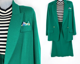 May include: A green blazer and skirt suit with a striped shirt underneath. The blazer has a pocket with a patterned handkerchief. The skirt has a high waist and a slightly flared hem.