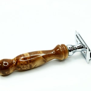 K&ouml;nnte beinhalten: Ein verchromter Sicherheitsrasierer mit einem Holzgriff. Der Griff ist aus braunem Holz mit einem Wirbelmuster.