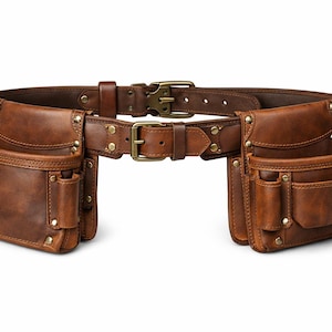 May include: A brown leather tool belt featuring two large side pouches with multiple compartments, reinforced with brass-colored metal rivets. The belt includes an adjustable strap with a brass-colored metal buckle for secure fastening around the waist.