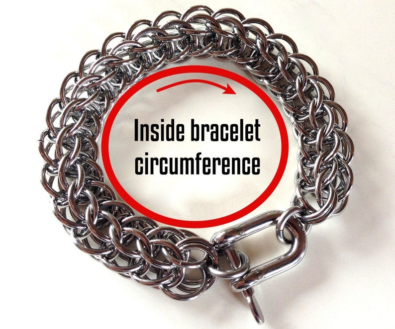 May include: Silver chainmail bracelet with a clasp. The inside circumference of the bracelet is marked with a red circle.