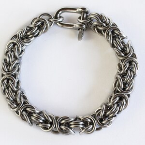 May include: A silver stainless steel bracelet with a chain link design and a lobster clasp.