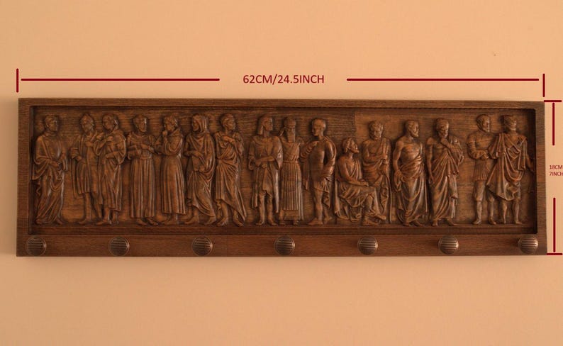 May include: A wooden wall-mounted coat rack with a carved relief of a group of people. The rack is 24.5 inches wide and 7.8 inches tall. It has six hooks for hanging coats, hats, or other items.