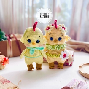 May include: Two handmade crochet chick dolls. One is yellow with a green scarf, the other is light yellow with a green collar and flower accents. Both have blue eyes and red crests. The image includes the text "CROCHET PATTERN" in a circular design.