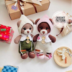 Puede incluir: Dos osos de peluche de ganchillo hechos a mano. Uno lleva un gorro blanco y un peto verde, el otro lleva un gorro rosa y un peto blanco. Ambos osos tienen pelaje marrón, ojos de botón y llevan zapatos. La imagen incluye el texto "CROCHET PATTERN".