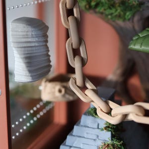 Close-up of the jumping spider enclosure’s detailed Aztec temple-style 3D-printed decor, highlighting textures, magnetic rock ledges, wood-effect hide, and pet-safe natural moss
