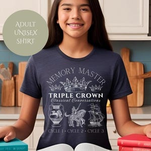 May include: A navy blue t-shirt with a white graphic design that says "Memory Master Triple Crown Classical Conversations Cycle 1, Cycle 2, Cycle 3". The graphic features a crown and three images of classical figures.