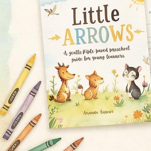 Pode incluir: Um livro infantil intitulado "Little Arrows" com ilustrações de animais de desenho animado e lápis de cor em várias cores. A capa do livro apresenta o texto "Little ARROWS" e o subtítulo "A gentle Kiple paved preschool guide for young learners."