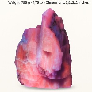 Könnte beinhalten: Ein rosafarbener Kunzit-Kristallpunkt mit einem Gewicht von 795 g und den Maßen 19x7.6x5 cm. Der Kristall ist ein leuchtendes Rosa mit lilafarbenen Farbtönen und trägt die Aufschrift "Energy Titan Kunzite Crystal Point". Der Text erwähnt auch "Heart Chakra, Emotional Healing, Light Flow".