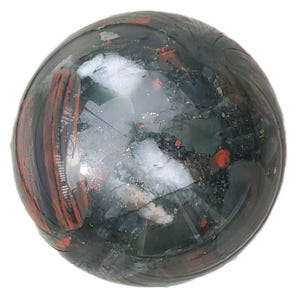 May include: A polished, spherical gemstone with a dark green base color, speckled with red and white inclusions. The stone has a smooth, reflective surface, and the red inclusions appear as small, irregular spots and streaks throughout the sphere.