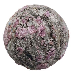 Könnte beinhalten: Ein runder Stein mit rauer Textur, der Grau-, Weiß- und Rosatöne aufweist. Die Oberfläche ist mit Clustern aus rosa Kristallen übersät, wodurch ein interessantes Muster entsteht. Es scheint sich um ein natürliches Mineralexemplar zu handeln.