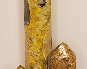 Puede incluir: Colección de obeliscos de piedra pulida en tonos amarillo, marrón y crema. El más alto es un rectángulo vertical, los otros son más pequeños, con puntas. Las piedras tienen patrones y texturas únicos. Medidas en cm.
