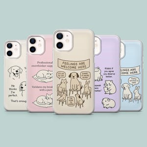 May include: Set of six phone cases featuring different illustrations of animals and text. The cases are all white with a clear back and have a variety of colors and designs. The text on the cases includes "Feelings are welcome here", "It's ok to cry", "Share if you're ready", "Ribbit if you agree you deserve better", "Every emotion is valid", and "Professional overthinker support".