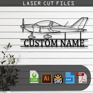 May include: A black laser cut file design featuring a side profile of a single-engine airplane silhouette positioned above the text CUSTOM NAME. The graphic includes icons for CDR, AI, SVG, DXF, and PDF file formats for digital cutting machines.