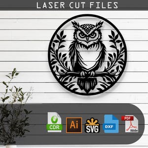 May include: Black laser-cut owl design. The owl is perched on a branch within a circular frame, surrounded by leaves. The text "LASER CUT FILES" is at the top. Includes file formats: CDR, AI, SVG, DXF, and PDF.