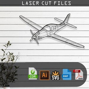 May include: A black wireframe airplane design against a white wood background. The text "LASER CUT FILES" is at the top. Below the plane are icons for CDR, AI, SVG, DXF, and PDF file formats.