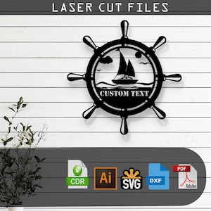 May include: Black metal ship wheel wall art with a sailboat design. The artwork features the text "CUSTOM TEXT" and the words "LASER CUT FILES" at the top. The image also includes file format icons for CDR, AI, SVG, DXF, and PDF.