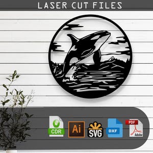 May include: Black and white laser cut file design of an orca jumping out of the water. The design is in a circle shape and includes a wave and a mountain in the background. The file is available in CDR, AI, SVG, and DXF formats.