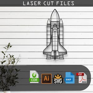 May include: A black and white line art design of a space shuttle, ready to be cut with a laser. The design is available in CDR, AI, SVG, and DXF file formats.