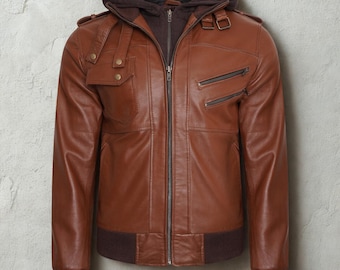 May include: A brown leather jacket with a detachable hood. The jacket features a zip-up front, multiple pockets, and a ribbed hem and cuffs. The jacket has a classic bomber style.