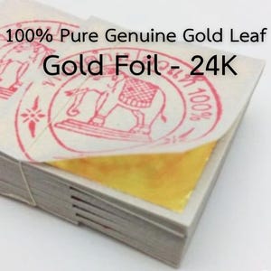 Peut inclure: Une pile de feuilles de dorure, la feuille supérieure partiellement décollée pour révéler l'or brillant. L'emballage porte des tampons rouges et le texte "100% Pure Genuine Gold Leaf Gold Foil - 24K".