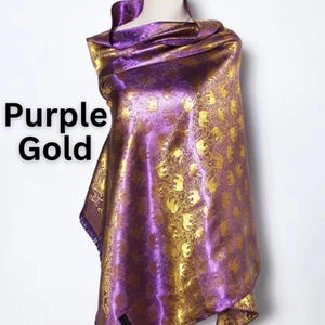 May include: A purple and gold scarf with an elephant pattern. The scarf is draped over a mannequin. The words "Purple Gold" are in the image.